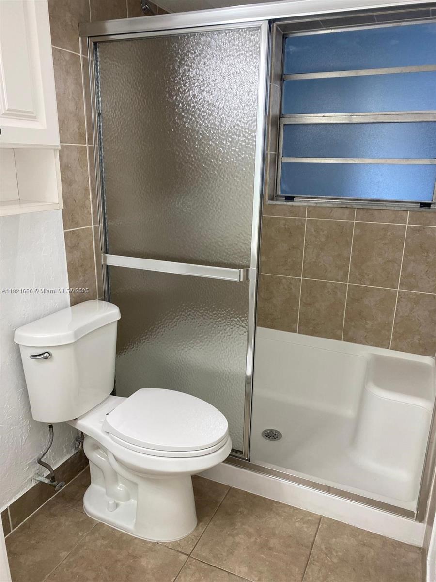 1725 West 60th Street, Unit F128 Hialeah, FL 33012 - Photo 14 of 21 a white toilet sitting next to a bath tub