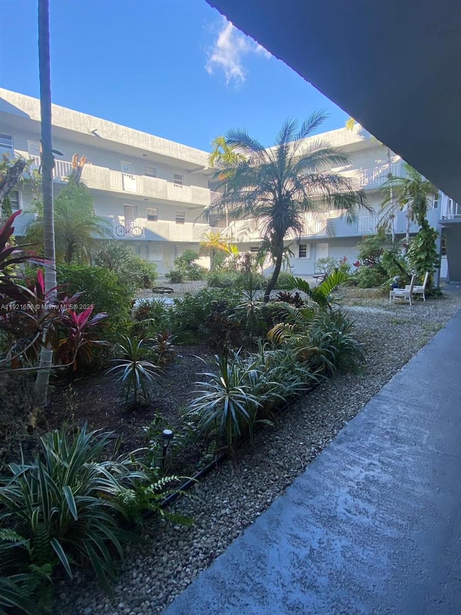 1725 West 60th Street, Unit F128 Hialeah, FL 33012 - Photo 16 of 21 a backyard of a house with a garden and outdoor seating