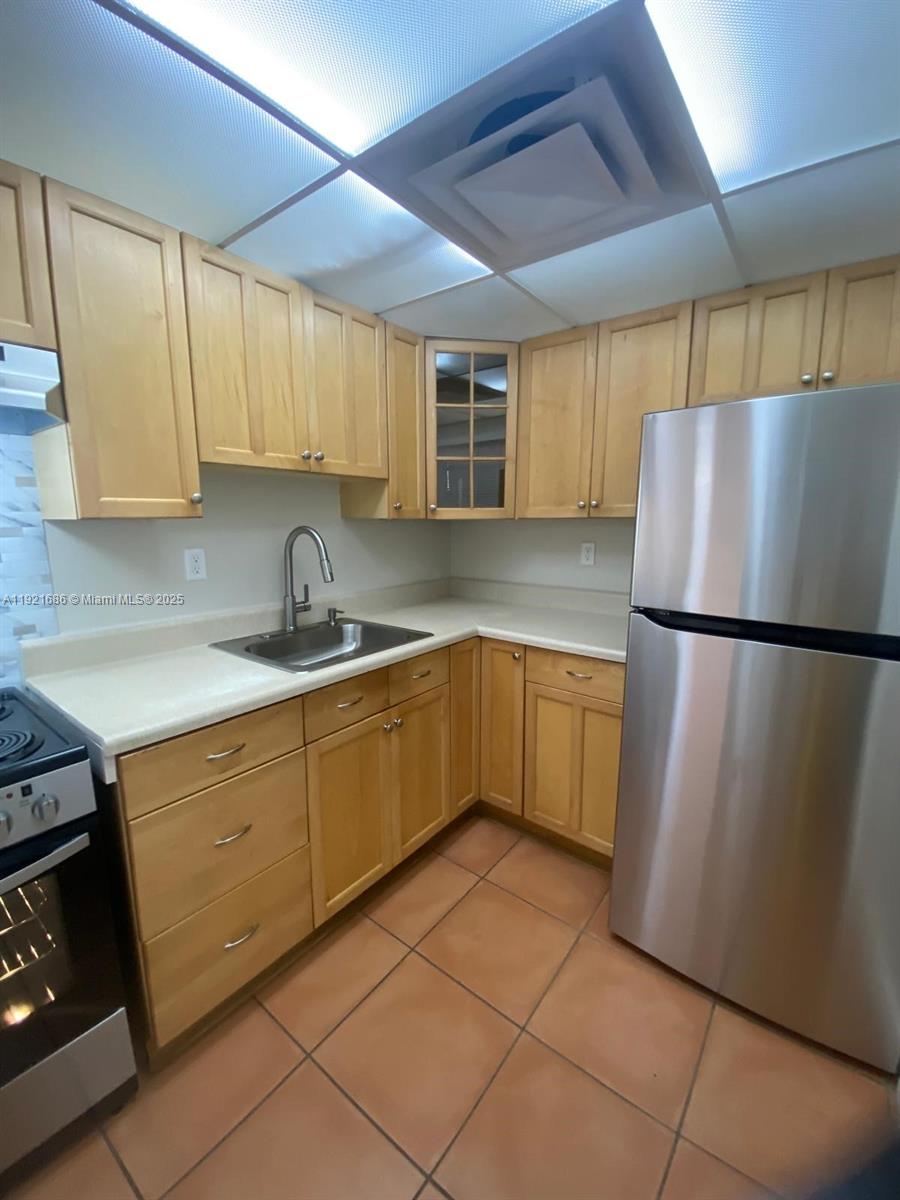 1725 West 60th Street, Unit F128 Hialeah, FL 33012 - Photo 3 of 21 a kitchen with a refrigerator sink and cabinets