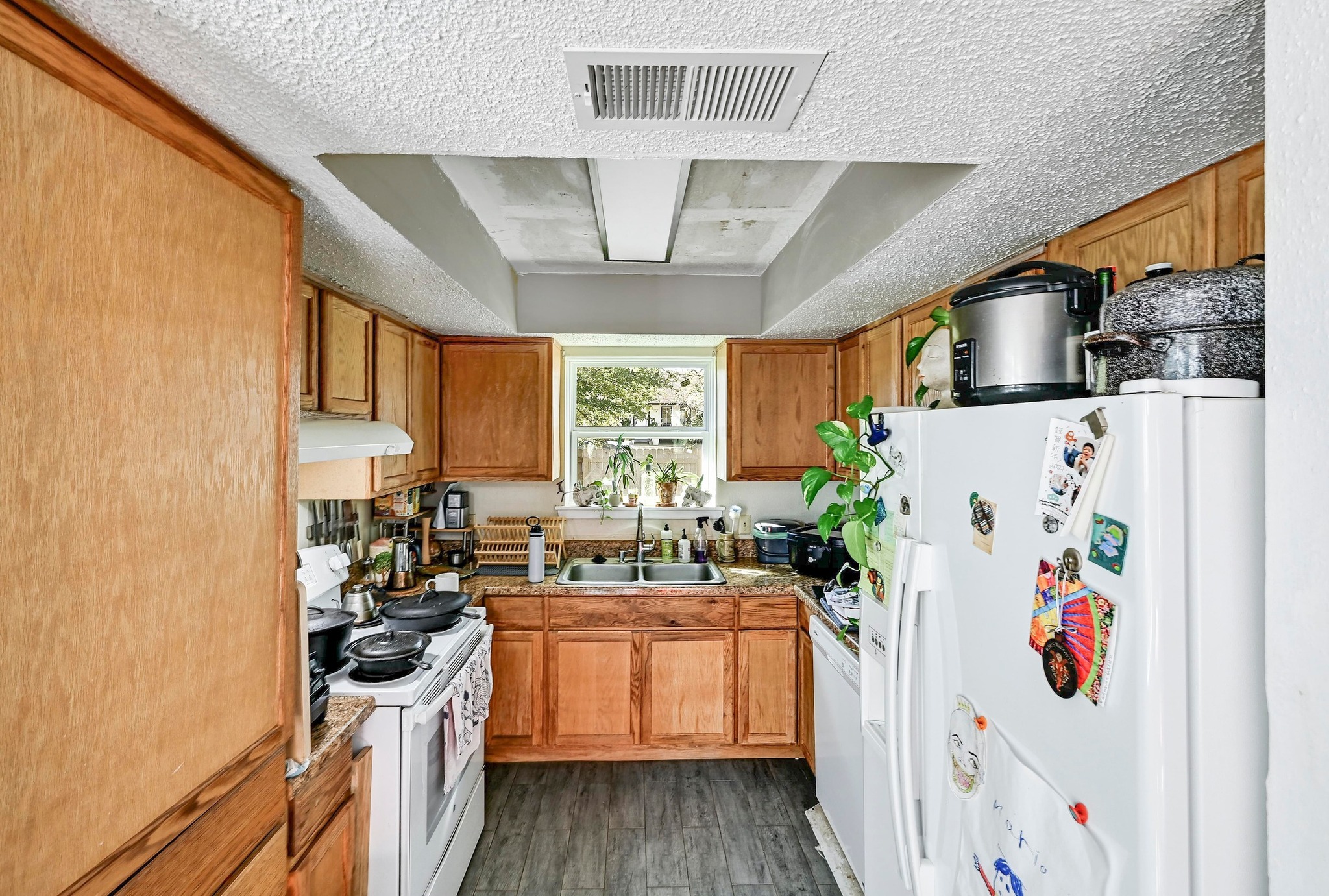 1208 Milford Way Austin, TX 78745 - Photo 8 of 22 a kitchen with a refrigerator a sink a stove and wooden floor