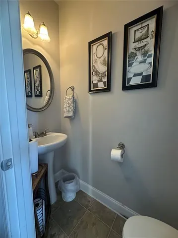 a bathroom with a toilet a sink and mirror