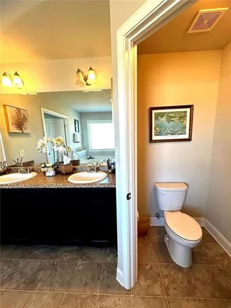 a bathroom with a sink vanity mirror and toilet