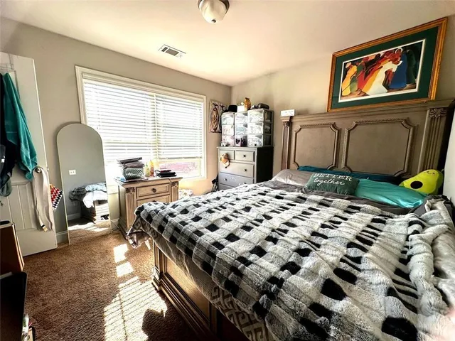a bedroom with bed and wooden floor
