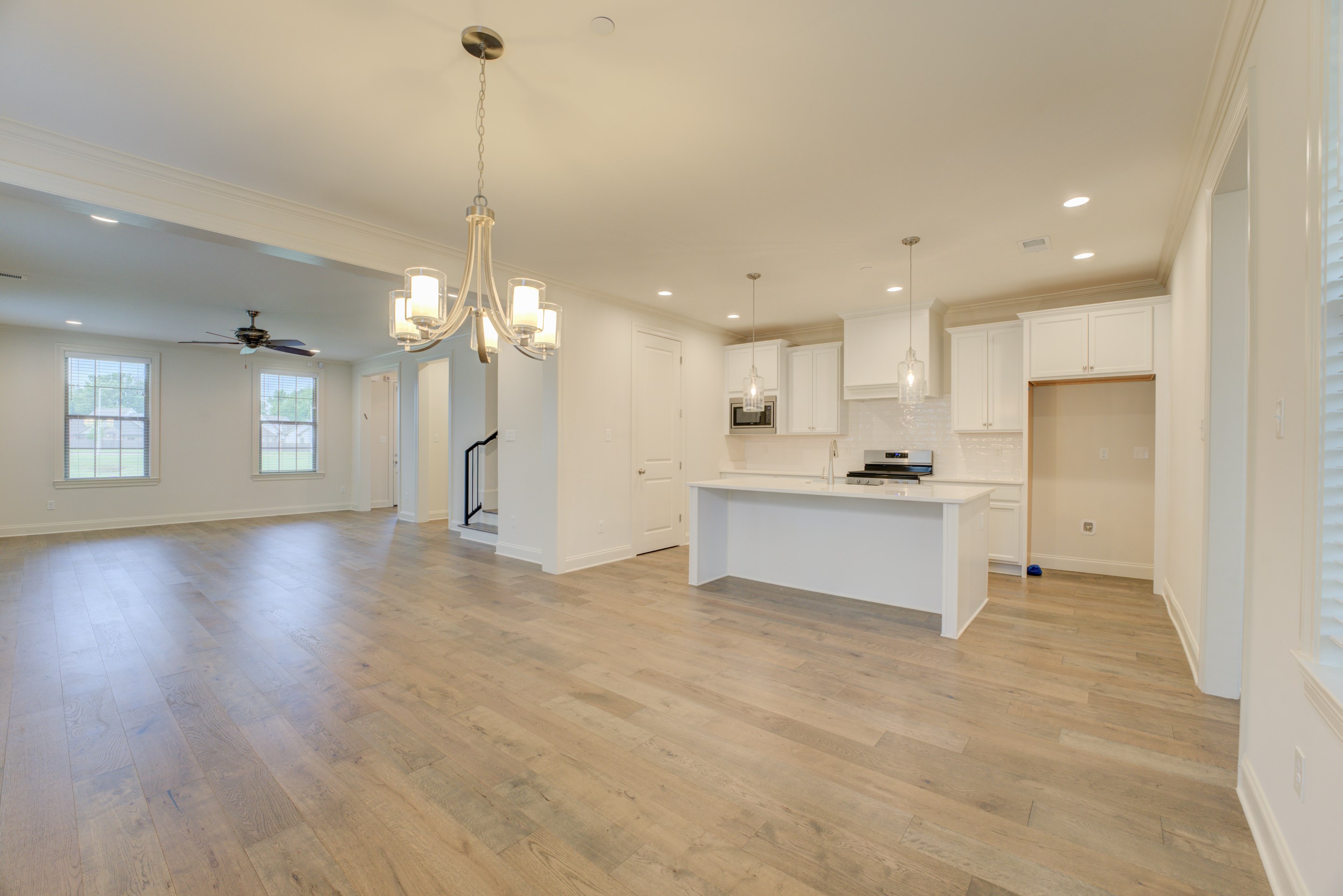 909 Ufton Alley Collierville, TN 38017 - Photo 4 of 29 a view of a kitchen with kitchen island a sink wooden floor and a refrigerator
