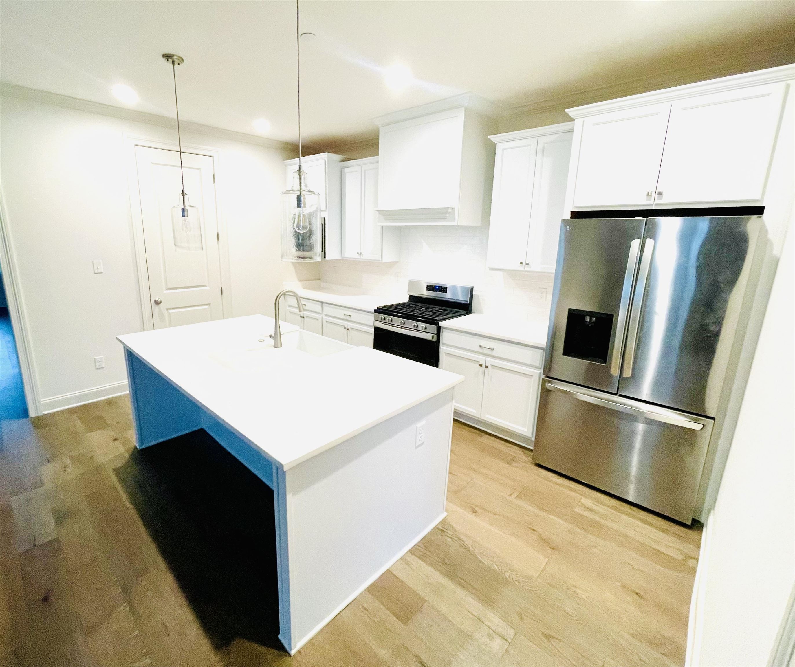 909 Ufton Alley Collierville, TN 38017 - Photo 6 of 29 a kitchen with kitchen island white cabinets appliances and wooden floor