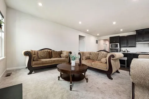 a living room with furniture and a view of kitchen