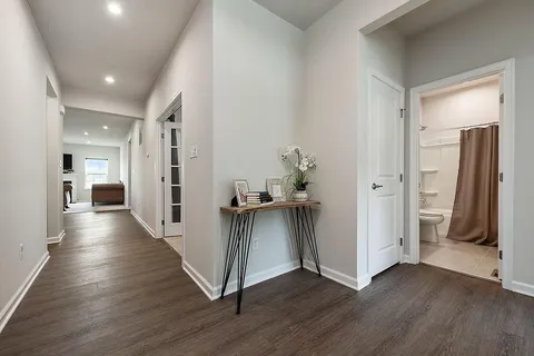 a view of a hallway with wooden floor and stairs