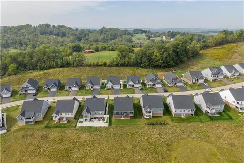 an aerial view of a house with a yard and lake view