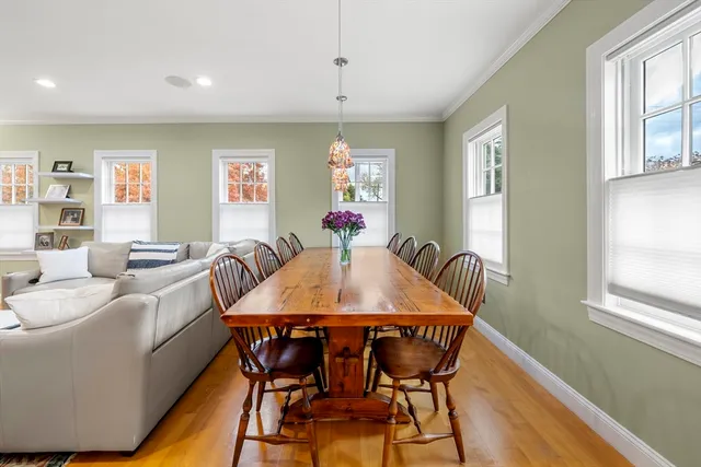 a hallway with wooden floor chandelier and entryway