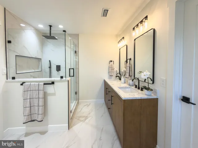 a spacious bathroom with a double vanity sink mirror and shower
