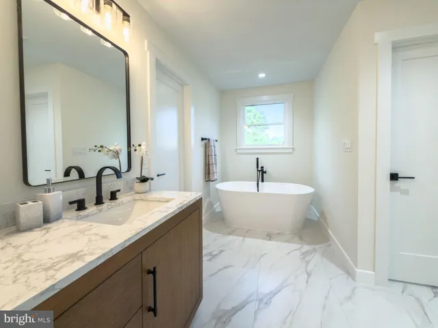 a bathroom with double vanity sinks a mirror and a bathtub