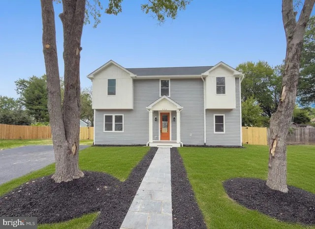 a front view of a house with a yard and trees