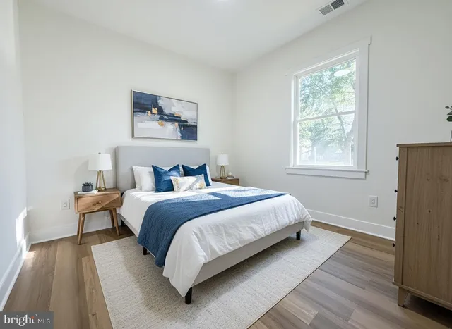 a bedroom with a bed and a painting on the wall