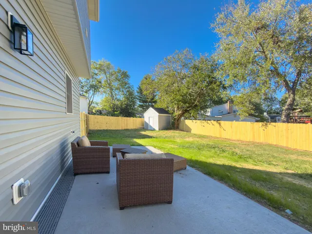 a backyard of a house with table and sofas