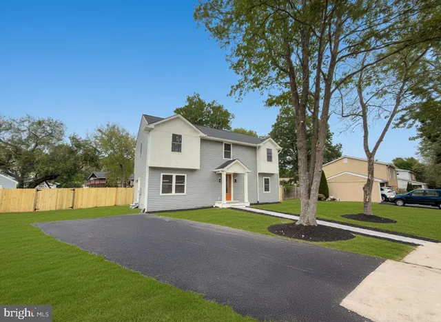 a view of a house with a big yard and large trees