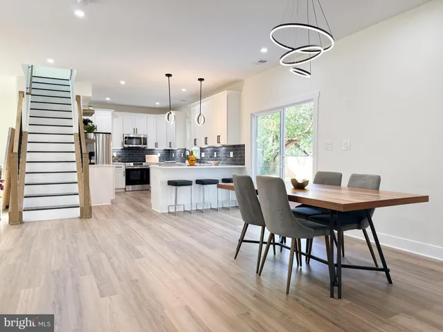 a kitchen with a table chairs and white cabinets