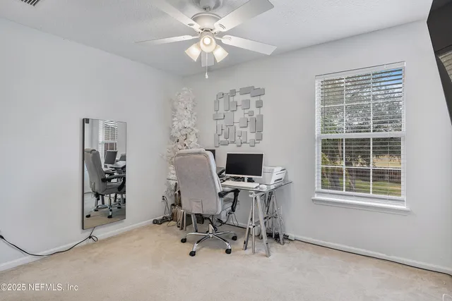 a view of a workspace with furniture and a window