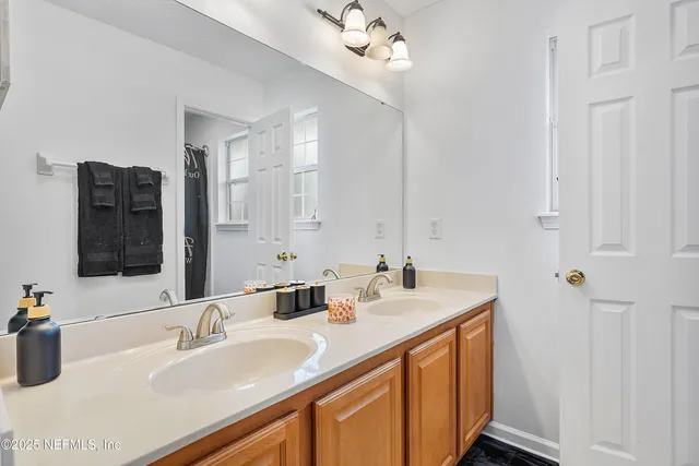 a bathroom with a sink double vanity granite and a mirror