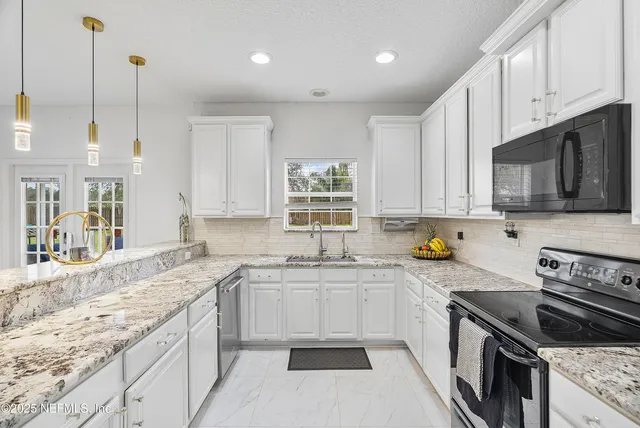 a kitchen with granite countertop a sink a stove and cabinets