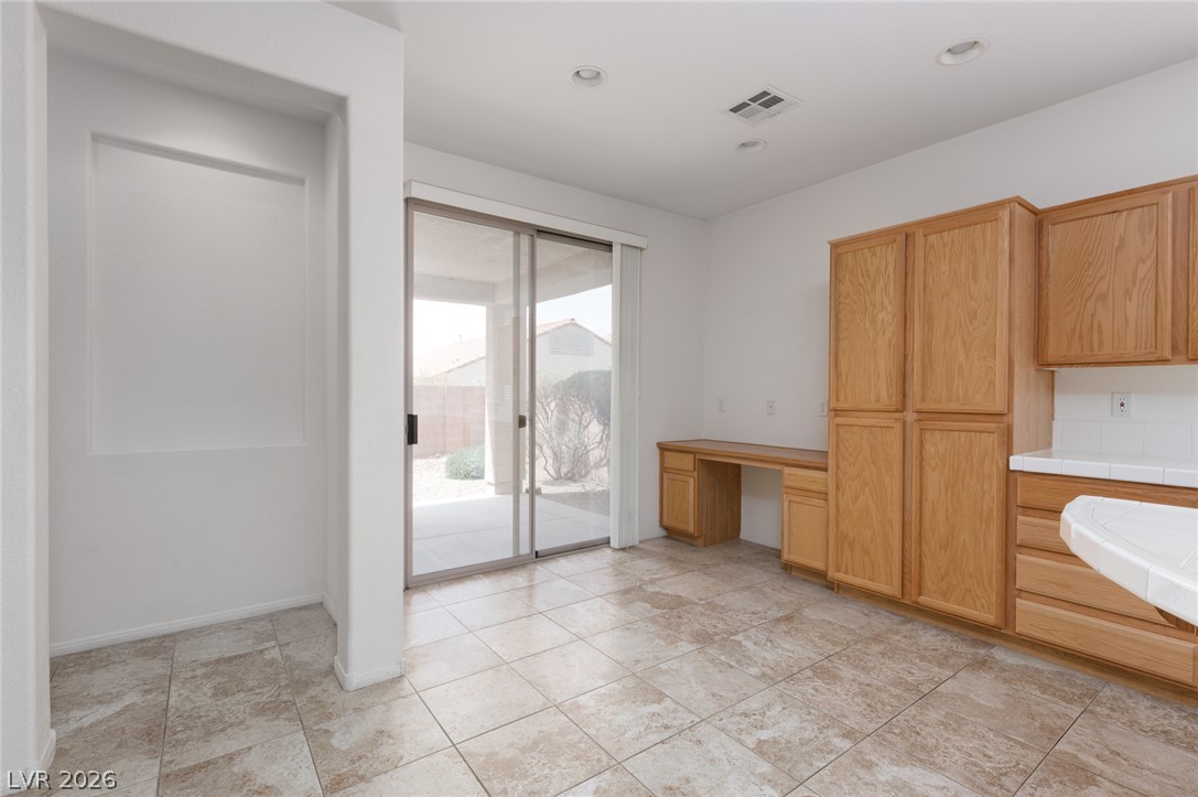 787 Rise Canyon Drive Henderson, NV 89052 - Photo 8 of 22 A well-lit area with warm wood cabinetry and a convenient desk space.