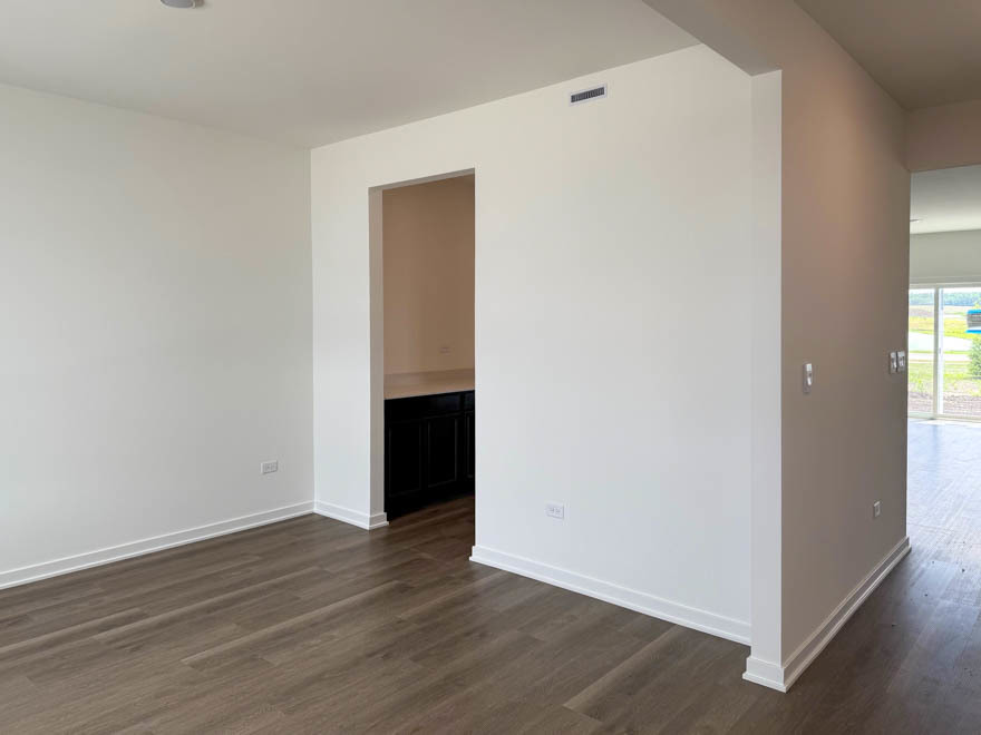 2459 Scribe Street Oswego, IL 60543 - Photo 2 of 26 a view of an empty room with wooden floor and a window