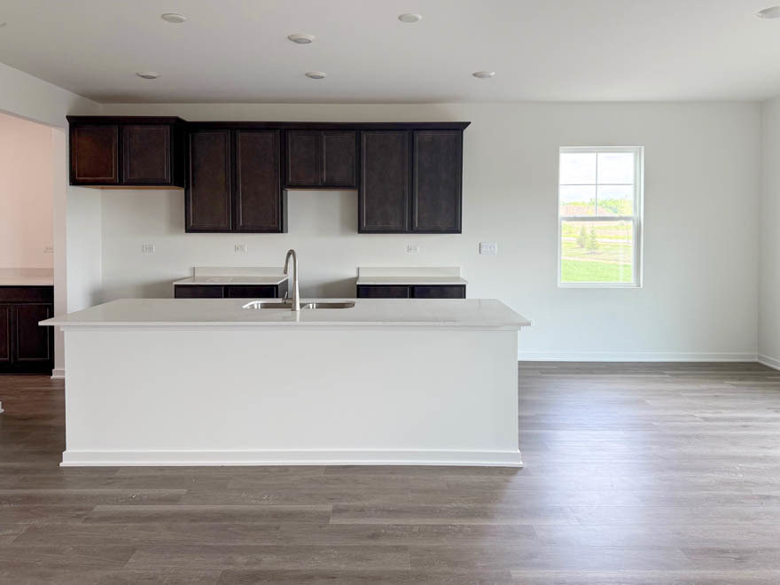 2459 Scribe Street Oswego, IL 60543 - Photo 5 of 26 a white kitchen with wooden floors a sink and a stove