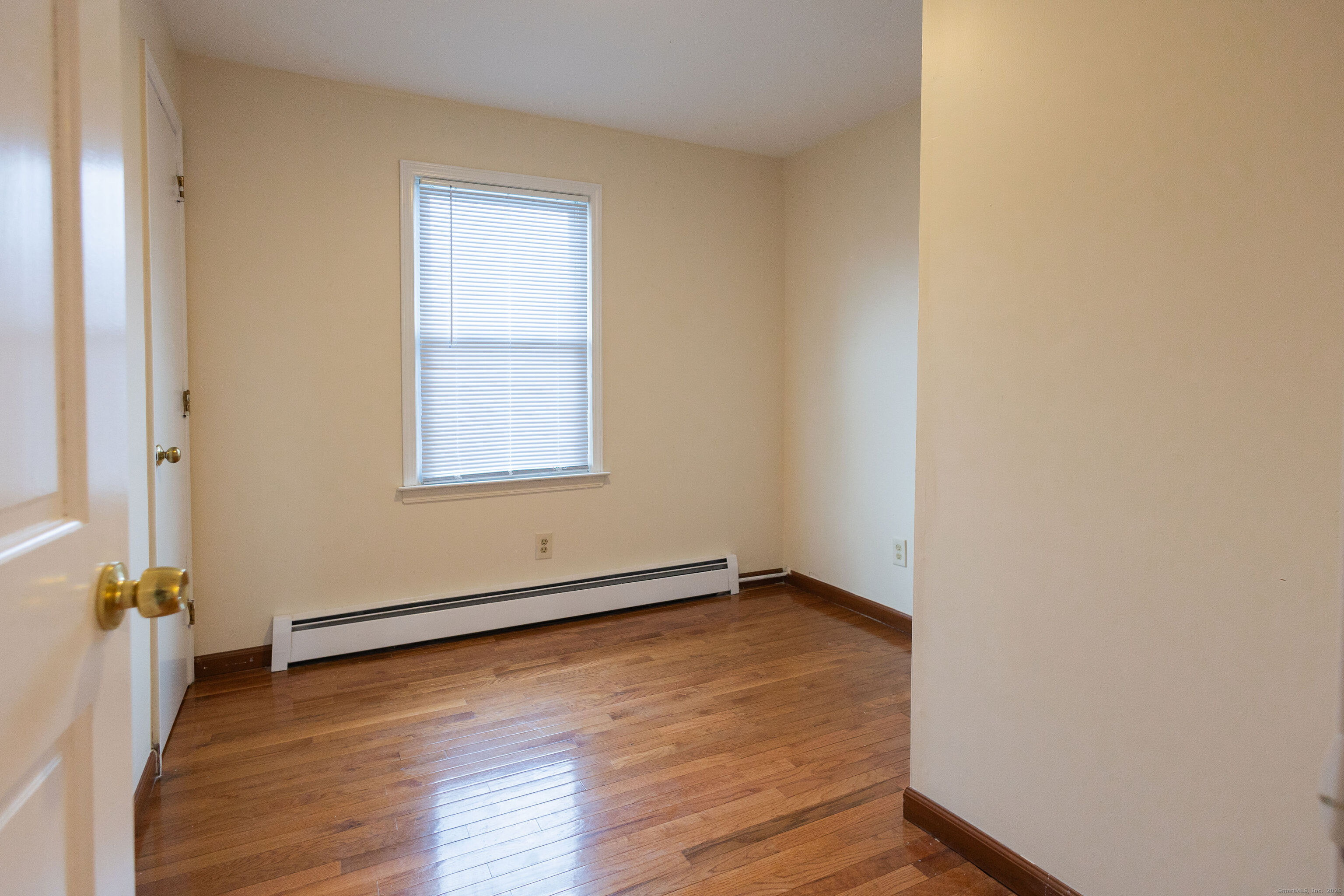 138 Infield Street Bridgeport, CT 06606 - Photo 17 of 31 an empty room with wooden floor and windows