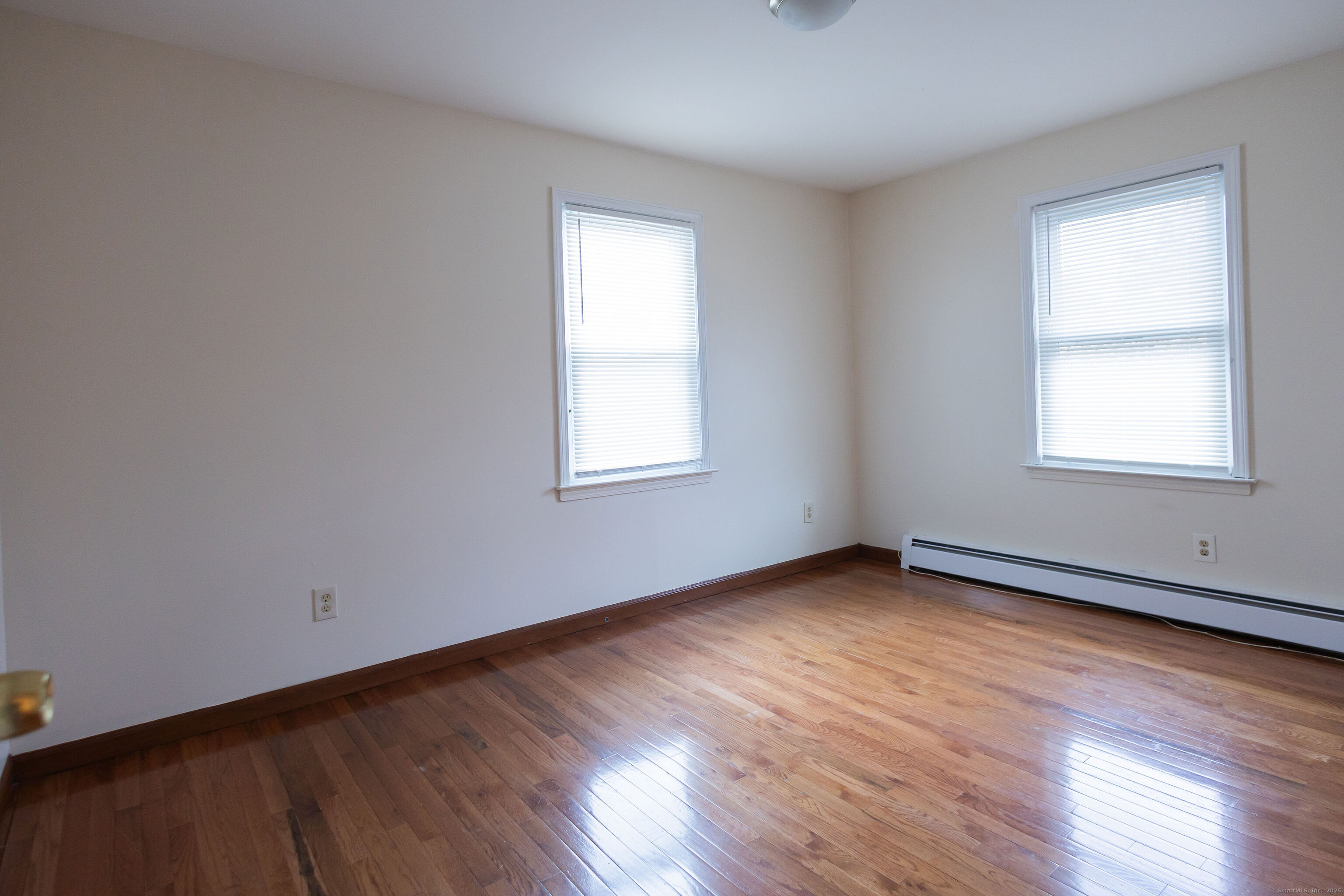 138 Infield Street Bridgeport, CT 06606 - Photo 19 of 31 an empty room with wooden floor and windows
