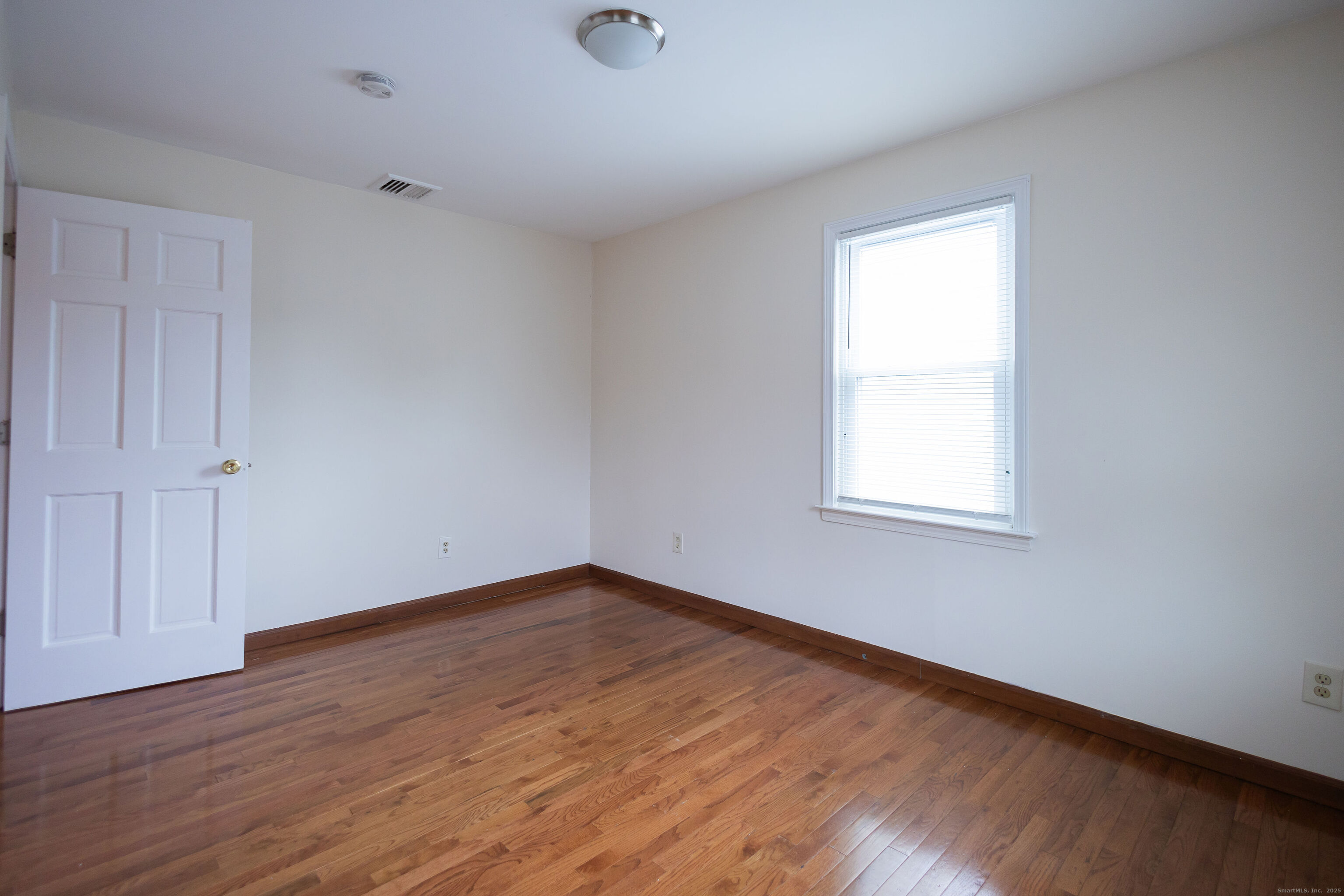 138 Infield Street Bridgeport, CT 06606 - Photo 20 of 31 an empty room with wooden floor and windows