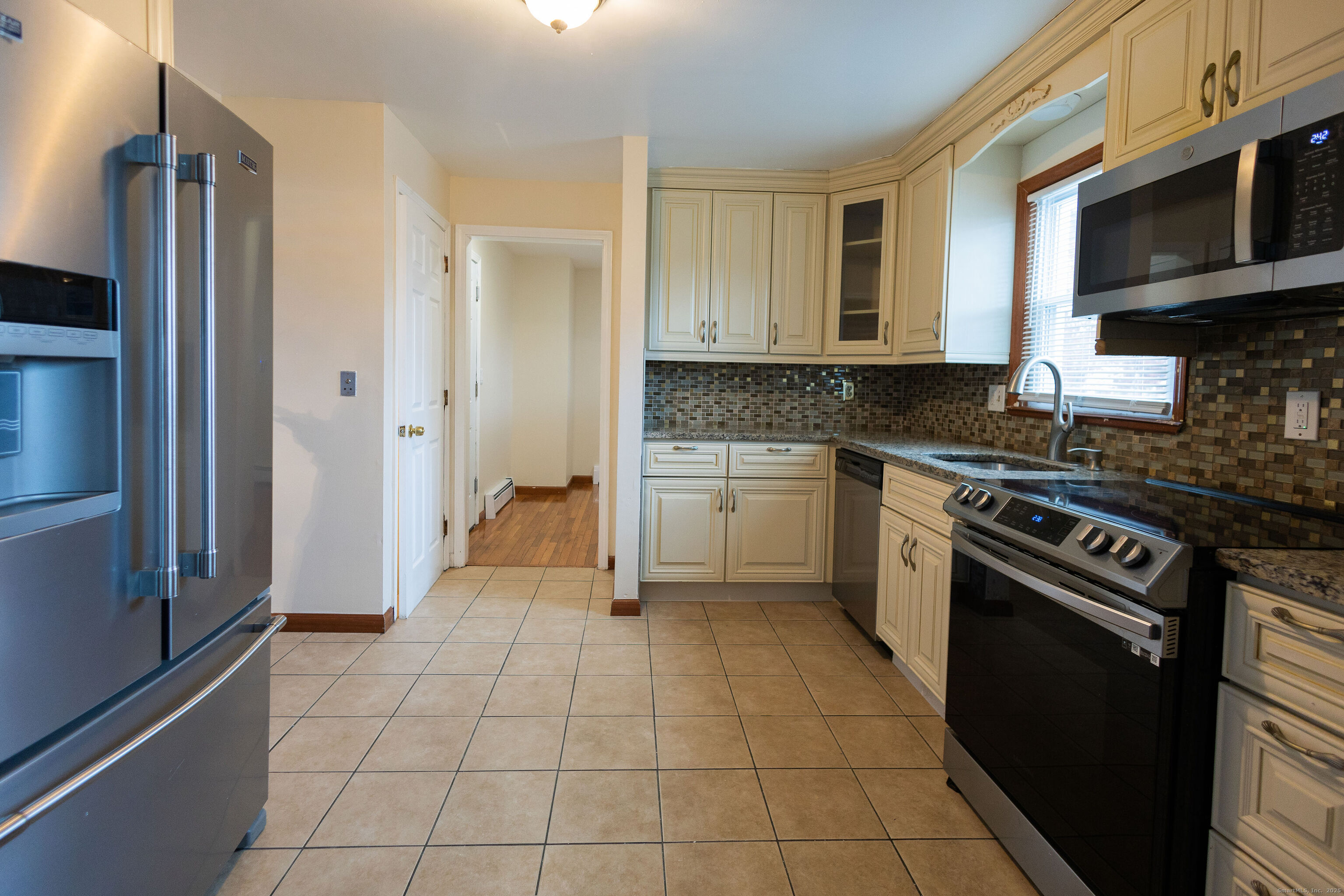 138 Infield Street Bridgeport, CT 06606 - Photo 8 of 31 a kitchen with a stove a sink and a refrigerator