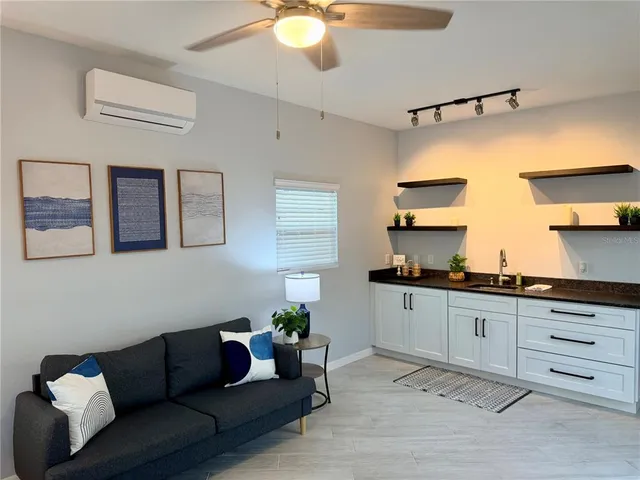 a living room with stainless steel appliances kitchen island granite countertop furniture and a wooden floor