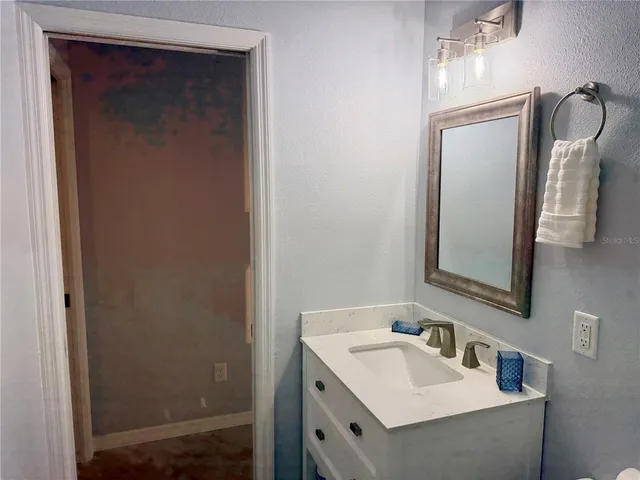 a bathroom with a sink vanity and mirror
