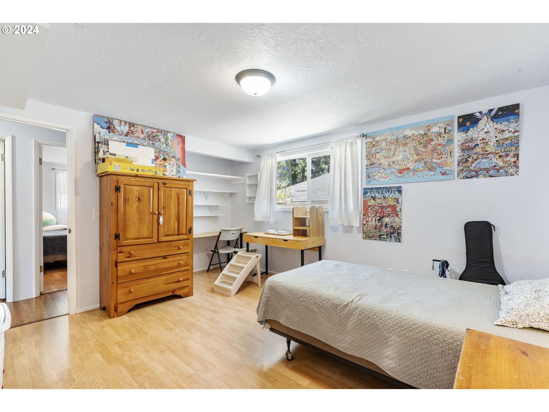 4409 Southwest Kanan Drive Portland, OR 97221 - Photo 12 of 25 a bedroom with a bed and dresser with mirror