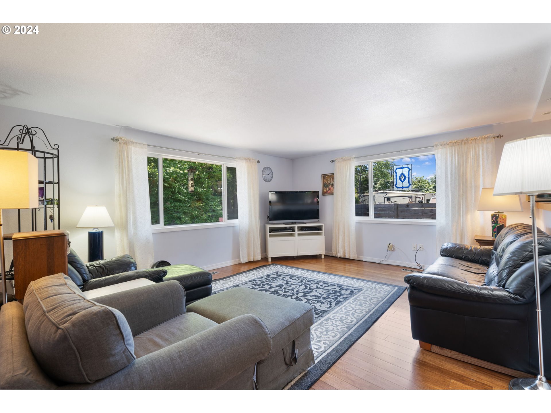 4409 Southwest Kanan Drive Portland, OR 97221 - Photo 7 of 25 a living room with furniture windows and a flat screen tv