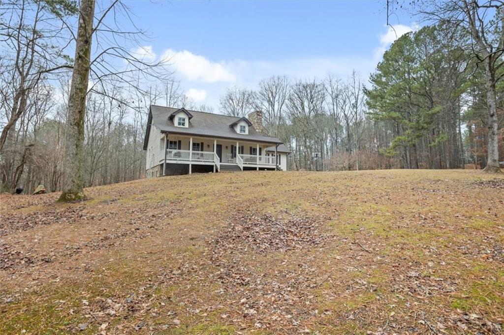 1075 Johnson Brady Road Canton, GA 30115 - Photo 12 of 30 a front view of a house with a yard covered with snow and trees