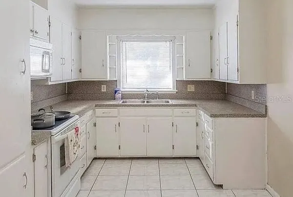 a kitchen with granite countertop white cabinets and white appliances