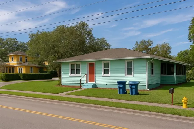 a view of a house in a big yard with plants and large trees