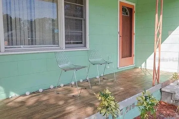 a view of a backyard with a chair and potted plants