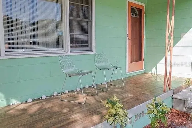 a view of a backyard with a chair and potted plants