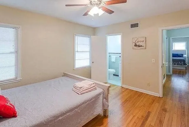 a bedroom with a bed and wooden floor