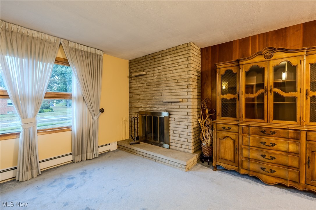 1950 Rush Road Wickliffe, OH 44092 - Photo 28 of 50 Living area with a large fireplace, carpet flooring, and wood walls