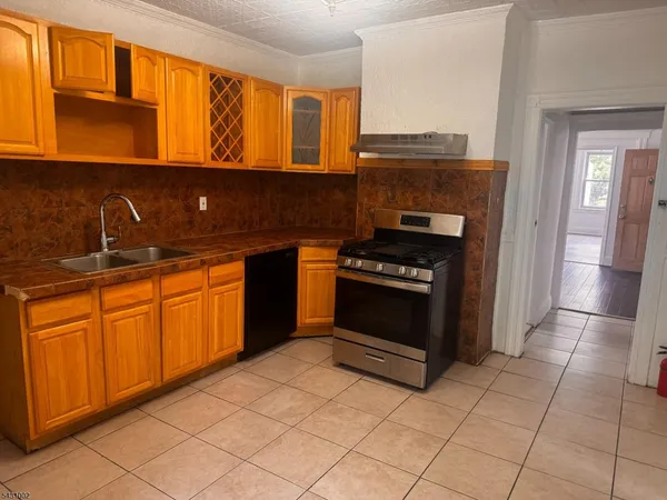 a kitchen with granite countertop a stove top oven sink and cabinets