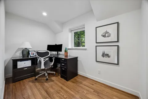 a view of a workspace with furniture and a window