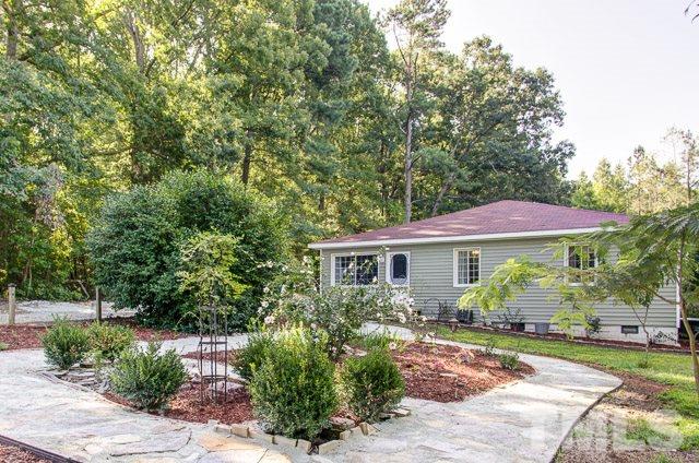 a view of a house with yard and sitting area