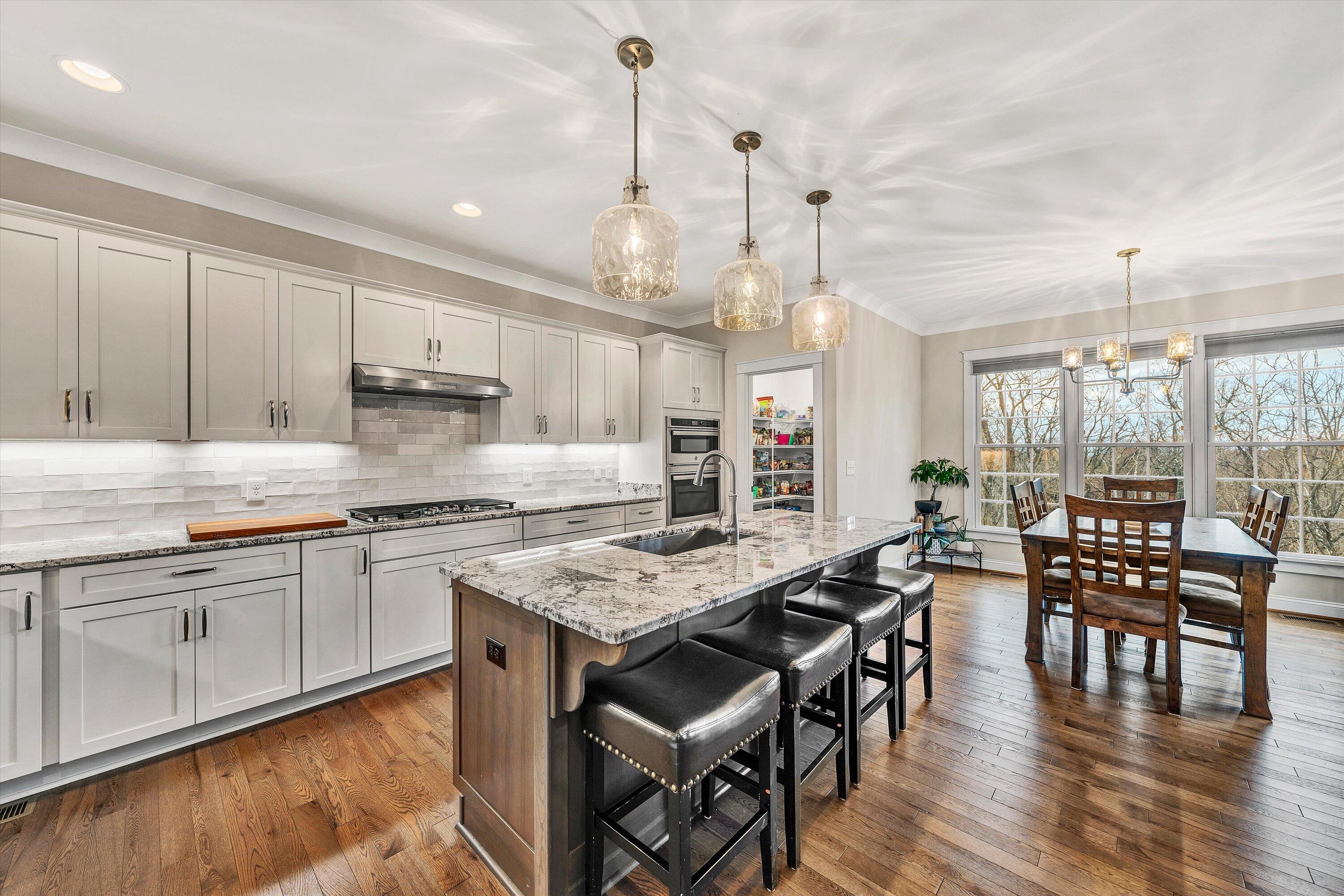6901 Fairway Ridge Road Salem, VA 24153 - Photo 13 of 58 a kitchen with stainless steel appliances granite countertop a stove top oven a sink a dining table and chairs with wooden floor