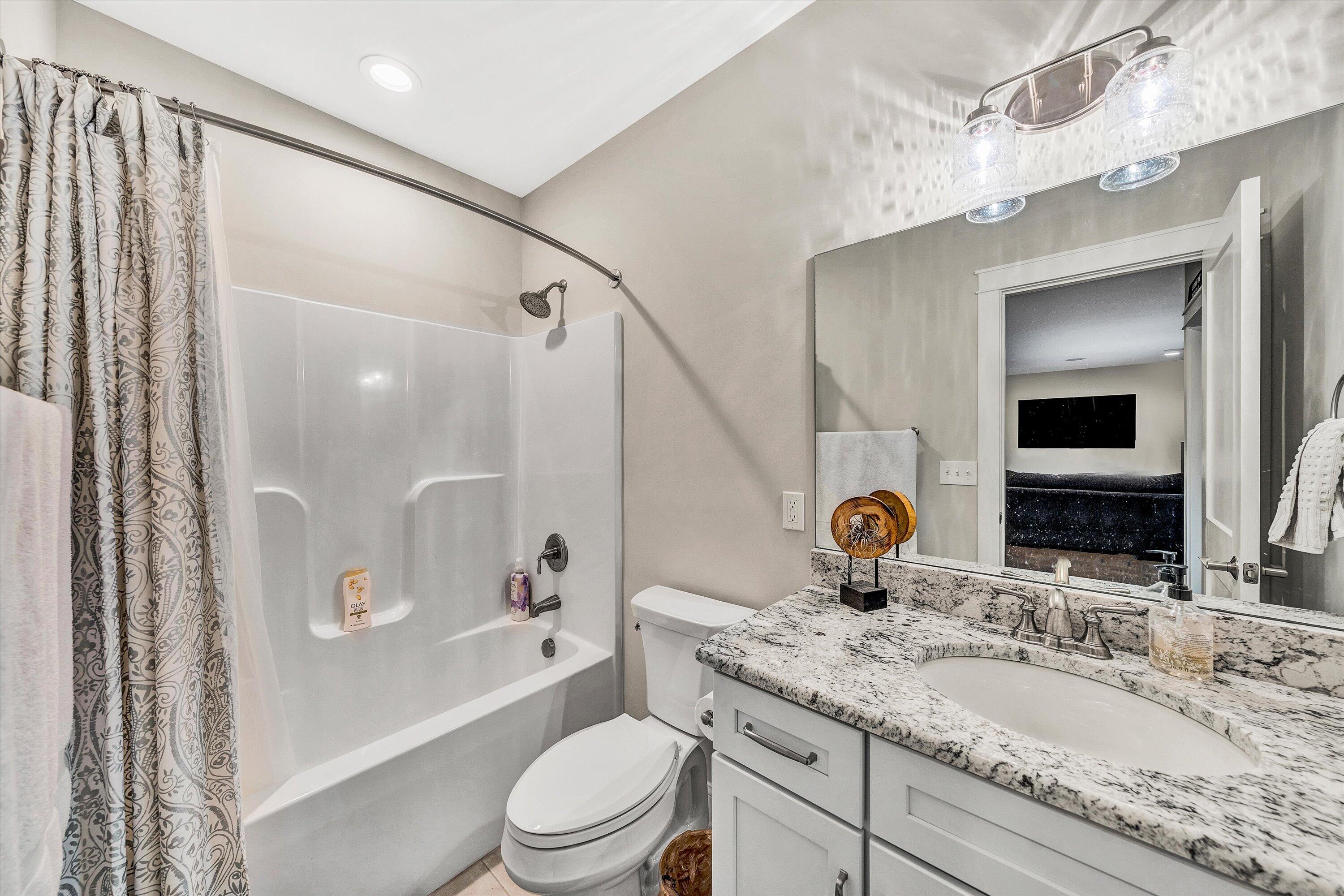 6901 Fairway Ridge Road Salem, VA 24153 - Photo 45 of 58 a bathroom with a granite countertop sink a mirror a bathtub and shower
