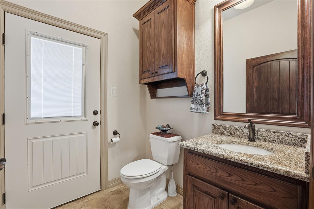 842 County Road 4371 Decatur, TX 76234 - Photo 23 of 35 a bathroom with a granite countertop sink a toilet and a mirror