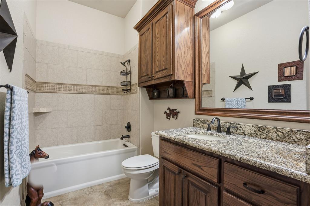 842 County Road 4371 Decatur, TX 76234 - Photo 7 of 35 a bathroom with a granite countertop bathtub sink vanity mirror and toilet