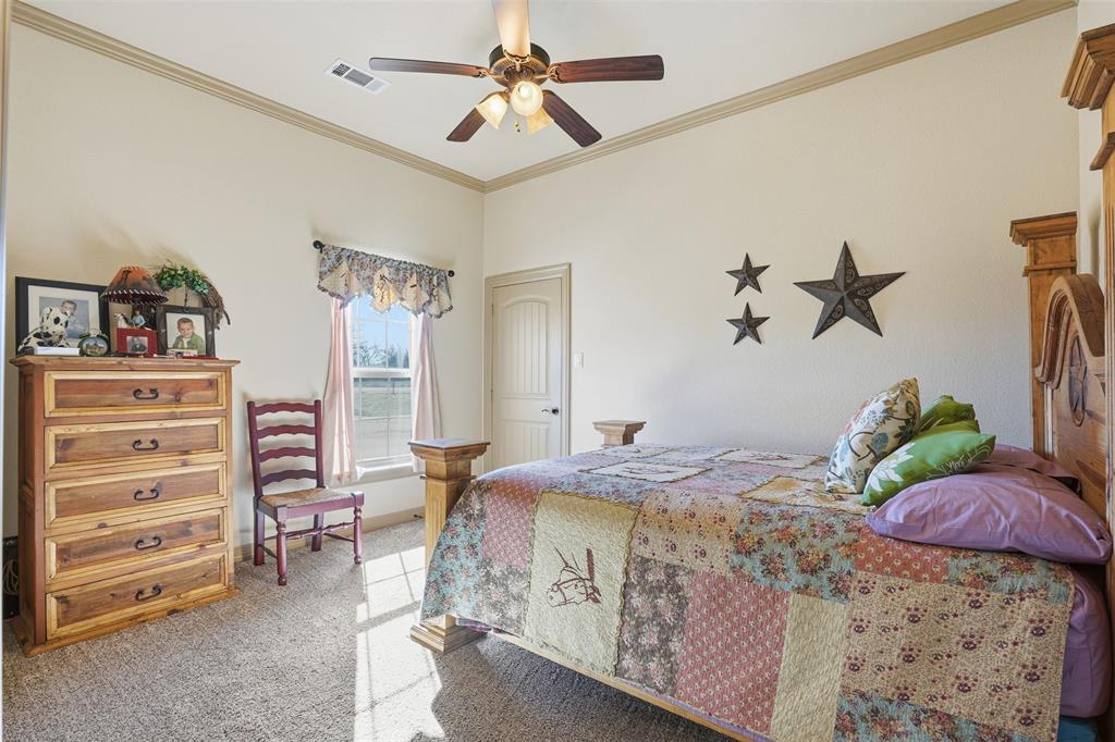 842 County Road 4371 Decatur, TX 76234 - Photo 8 of 35 a bedroom that has a bed and a chandelier