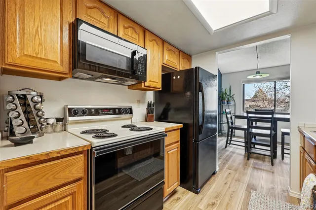 a kitchen with stainless steel appliances a stove a microwave and wooden cabinets